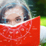 Девушка лежит на зеленой траве с книгой, украшенной знаками зодиака, погружаясь в чтение гороскопа на май под открытым небом. - ИА SakhaLife.Ru